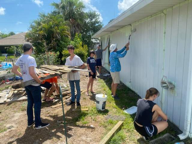 The crew tears down old fence and paints the exterior of Polly's house