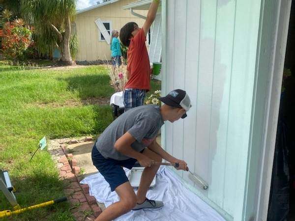 The boys painting outside the garage
